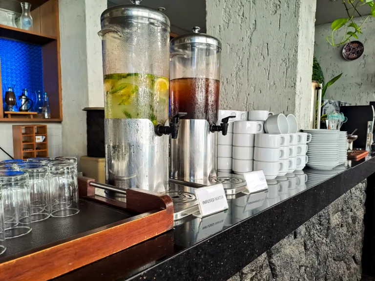 Infused water and lemongrass tea cold drink in dispenser glass on the table of kitchen bar, look fresh. hotel beverage dispenser