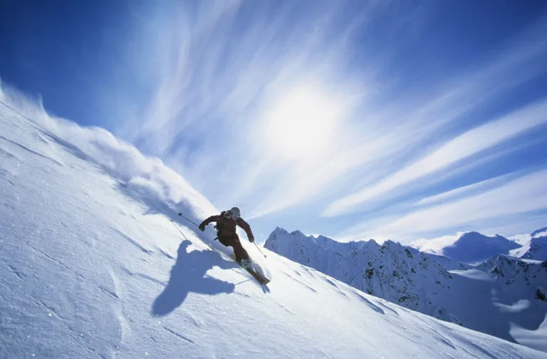 Full length of skier skiing on fresh powder snow
